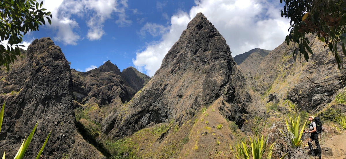green grass and gray rocky mountain under blue sky during daytime