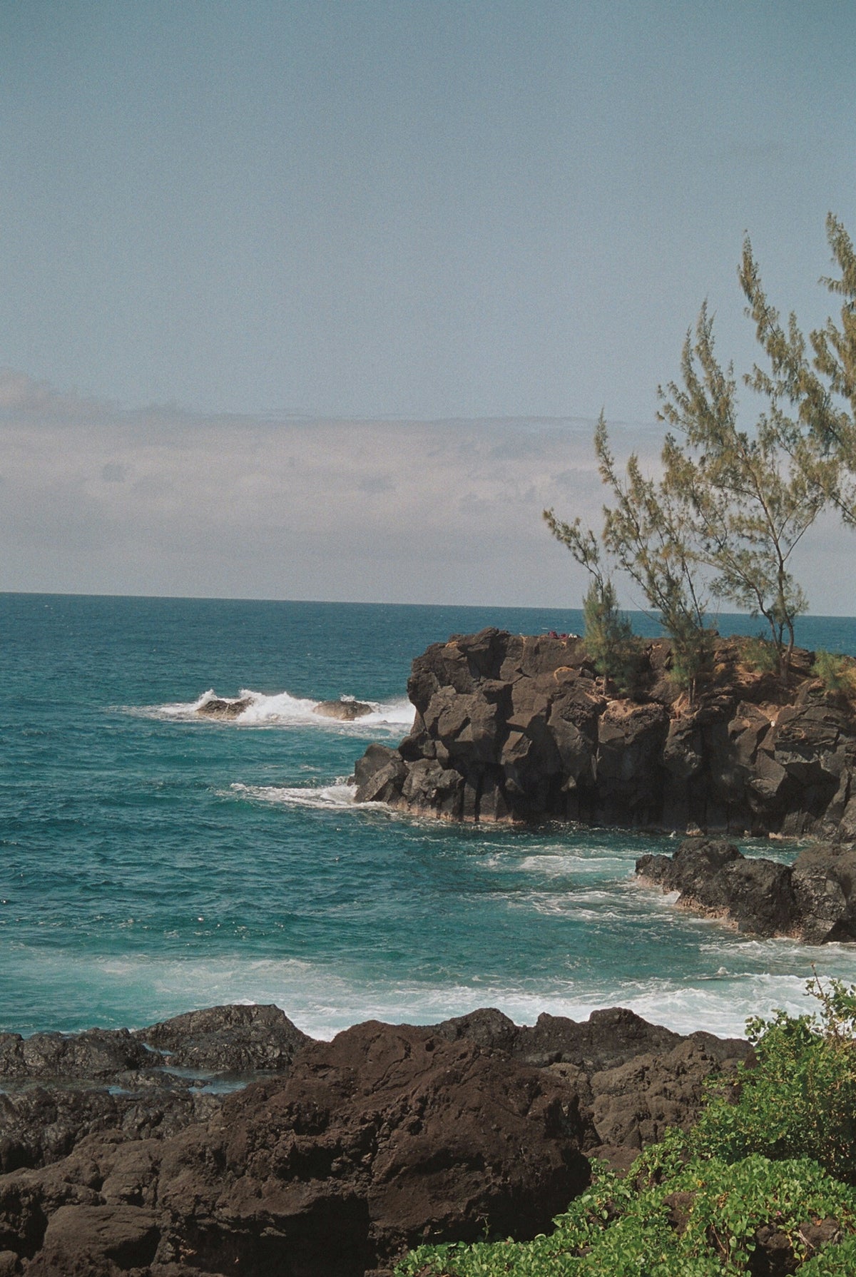 a large body of water sitting next to a rocky shore